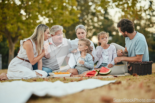 Image of Happy family, park picnic and summer with fruit, eating and love in nature, holiday and bonding in spring. Big family, healthy watermelon and kids with mom, dad and grandparents on lawn in Melbourne