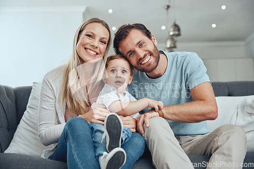 Image of Happy, smile and portrait of a family on a sofa relaxing, bonding and holding their child at their home. Mother, father and baby boy sitting in the living room together with love, care and happiness.