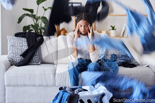 Image of Laundry, clothes or black woman with stress, headache or anxiety frustrated with cleaning, washing basket or housekeeping. Burnout, fatigue or tired African girl cleaner resting on living room sofa