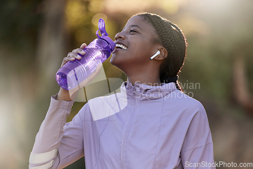 Image of Exercise, black woman and drinking water for fitness, wellness and health outdoor to relax. Sports, young female Nigerian and athlete hydration, liquid for break and training for workout and earbuds.