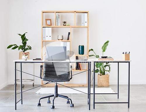 Image of Empty office, table or desk in a home office interior or office desk with pens, plants or stationery for productivity. Furniture, chair or modern office room with laptop or folders in a wooden shelf