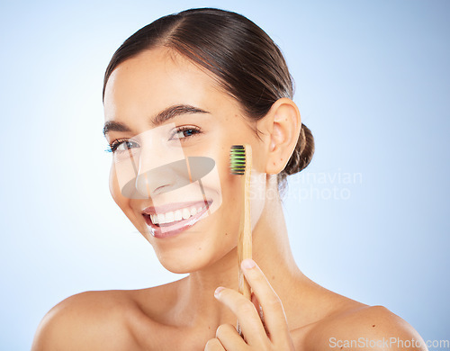 Image of Face portrait, dental and woman with toothbrush in studio isolated on a blue background. Oral wellness, veneers and happy female model holding product for brushing teeth, cleaning and oral hygiene.