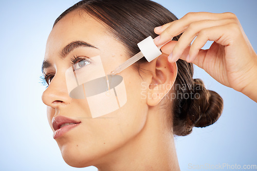 Image of Face, skincare and woman with serum for beauty in studio on a background. Thinking, cosmetics and female model with hyaluronic acid, essential oil and dropper product for healthy skin and anti aging.
