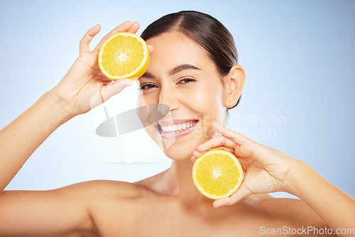 Image of Woman, skincare portrait and lemon for beauty, health and wellness with vitamin c, happy and smile. Model, fruit and happiness for self care, clean radiant glow and skin by blue background in studio