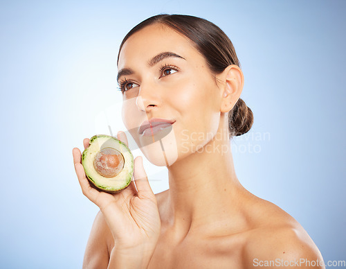 Image of Beauty, health and skincare with woman and avocado for facial, natural products and detox. Nutrition, spa and diet with face of girl model for self care, wellness and glow in blue background studio