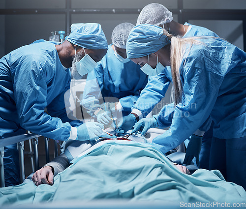 Image of Doctors, surgery and collaboration with a medicine team in scrubs operating on a man patient in a hospital. Doctor, nurse and teamwork with a medical group in a clinic to perform an operation