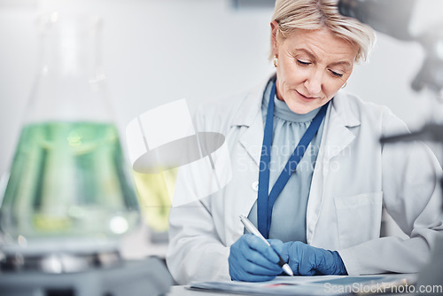 Image of Science, research and senior woman writing notes on documents in laboratory. Innovation, thinking and elderly female scientist researching, recording and write experiment results, analysis or report.
