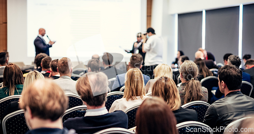 Image of I have a question. Group of business people sitting in conference hall. Businessman raising his arm. Conference and Presentation. Business and Entrepreneurship