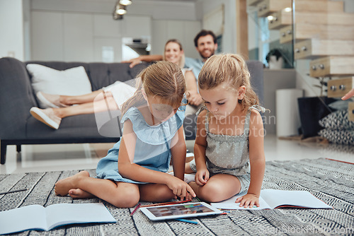 Image of Living room, parents relaxing and children doing elearning on tablet in books on the floor in their home. Mother, father and girl kids sitting in lounge together for homeschool learning and studying.