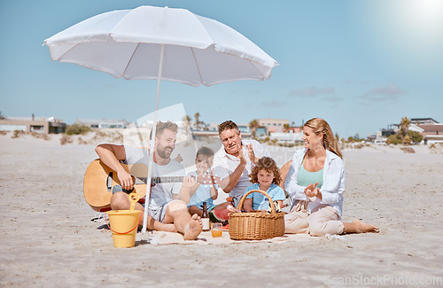 Image of Beach, picnic or happy family love guitar music while bonding or relaxing on summer holiday vacation. Grandfather, dad and mother enjoying quality time with children siblings eating watermelon fruit