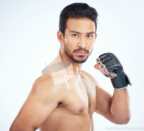 Image of Face portrait, mma sports and man in studio on a blue background. Martial arts, body fitness and serious male fighter or boxer ready for training, workout or exercise for battle, match or competition
