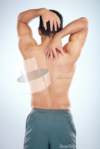 Image of Man, body or stretching back muscles on blue background in studio pain relief, healthcare wellness or burnout tension release. Sports athlete, fitness model or coach flexing in workout success check