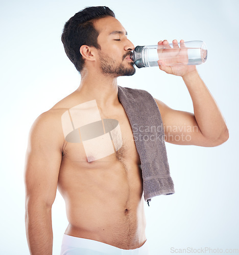 Image of Fitness, health or man drinking water in studio after training in workout or exercise for body goals or wellness. Motivation, weight loss or tired healthy person relaxing and drinks liquid or bottle