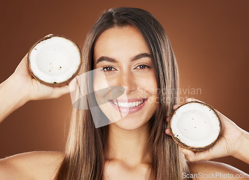 Image of Woman, skincare and coconut in studio, happy or smile for self care, nutrition or cosmetic health. Model, skin wellness and fruit for oil, moisturizer or cosmetics background for natural radiant glow