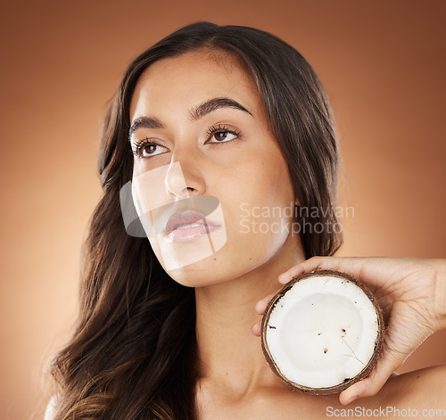 Image of Coconut skincare beauty, woman and studio for health, wellness and natural radiant glow by backdrop. Model, face and fruit for nutrition, cosmetics or coconut oil for skin moisturizer by background
