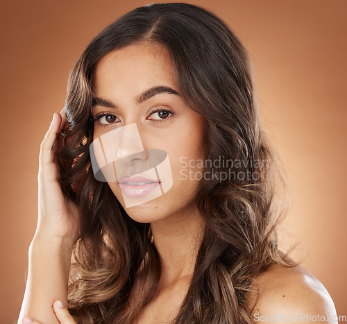 Image of Woman, face skincare or curly hairstyle on brown studio background in color dye advertising, self love or Brazilian keratin treatment. Portrait, beauty model or brunette waves and natural makeup glow