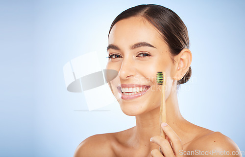 Image of Face portrait, dental and woman with toothbrush in studio isolated on a blue background. Oral wellness, veneers and happy female model holding product for brushing teeth, cleaning and oral hygiene.