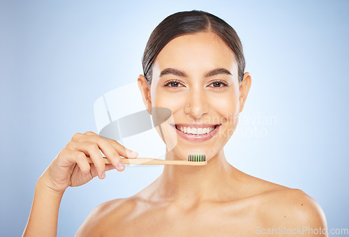 Image of Face portrait, dental and woman with toothbrush in studio isolated on a blue background. Oral wellness, veneers and happy female model holding product for brushing teeth, cleaning and oral hygiene.