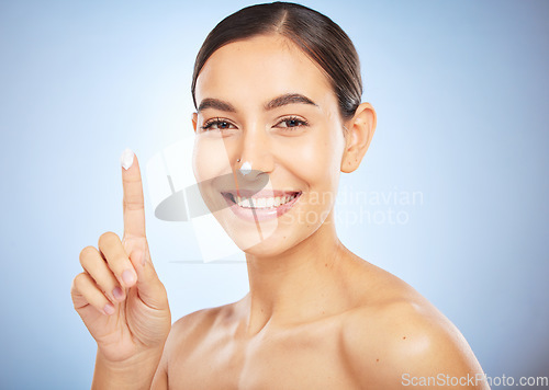 Image of Portrait, skincare and moisturizer with a model woman in studio on a gray background for antiaging beauty. Face, lotion and product with an attractive young female inside to apply facial treatment