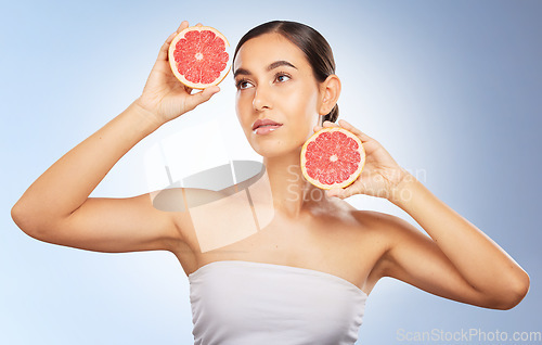 Image of Woman, beauty and natural skincare with grapefruit, radiant glow and healthy aesthetic by blue background. Model, skin shine and fruit for wellness, self care and cosmetic health by studio background