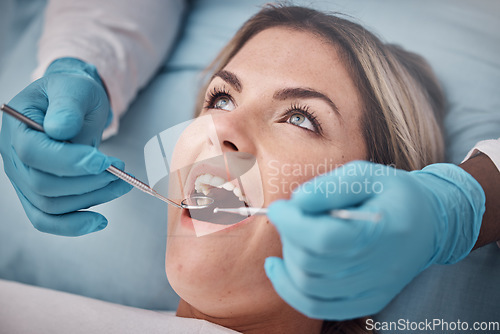 Image of Dental, teeth and woman at the dentist for a check up, tooth whitening or cavity removal procedure. Dentistry, oral care and hands of a doctor checking the mouth of female patient with medical tools.