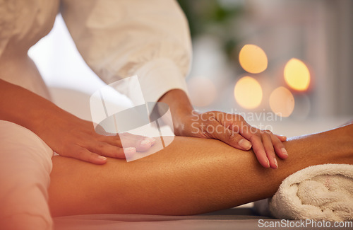 Image of Spa, hands and legs massage for relax, health and wellness at luxury resort. Zen, physical therapy and woman or female .therapist massaging leg of person on table for skincare, body care and beauty.