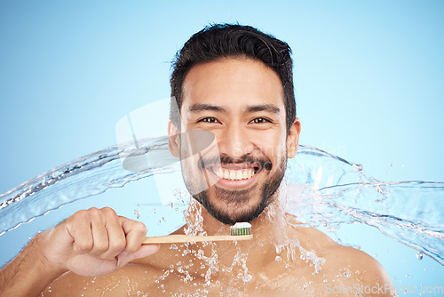 Image of Water splash, portrait or man brushing teeth in studio with toothbrush for white teeth or oral healthcare. Face, tooth paste or happy person cleaning or washing mouth with a healthy dental smile