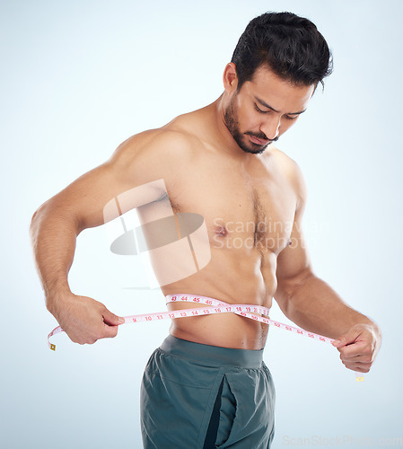 Image of Man, body or measuring tape on waist on studio background for weight loss management, fat control or bmi and diet wellness. Fitness model, sports athlete or coach with tape measure for muscle goals