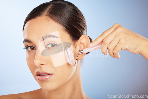 Image of Beauty, portrait or woman with a roller for skincare in facial grooming routine in studio with advertising mockup space. Product, luxury or girl model with cosmetics, natural glowing or smooth face