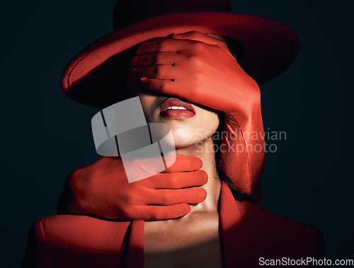 Image of Fashion, spotlight and sensual woman in studio with a seductive, desire and alluring pose. Beauty, fashionable and sexy girl model with stylish, fancy and edgy red outfit isolated by black background