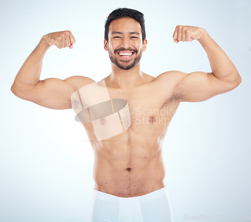 Image of Fitness, biceps and portrait of a man flexing in a studio after an arm muscle training workout. Sports, health and strong Asian male bodybuilder after a strength exercise isolated by white background