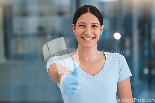 Image of Cleaning woman, thumbs up portrait and office with smile, gloves and safety with happiness by blurred background. Happy hygiene expert, face and hand sign for motivation, goals and cleaning service