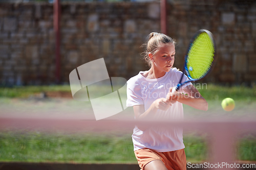 Image of A young girl showing professional tennis skills in a competitive match on a sunny day, surrounded by the modern aesthetics of a tennis court.