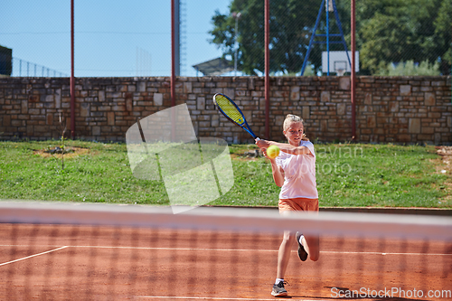 Image of A young girl showing professional tennis skills in a competitive match on a sunny day, surrounded by the modern aesthetics of a tennis court.