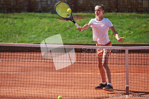 Image of A young girl showing professional tennis skills in a competitive match on a sunny day, surrounded by the modern aesthetics of a tennis court.