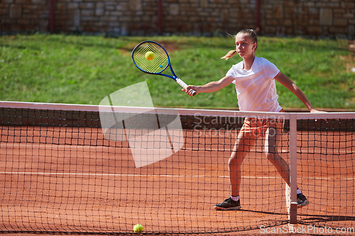 Image of A young girl showing professional tennis skills in a competitive match on a sunny day, surrounded by the modern aesthetics of a tennis court.