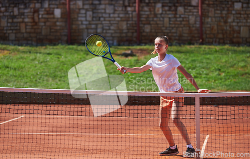 Image of A young girl showing professional tennis skills in a competitive match on a sunny day, surrounded by the modern aesthetics of a tennis court.