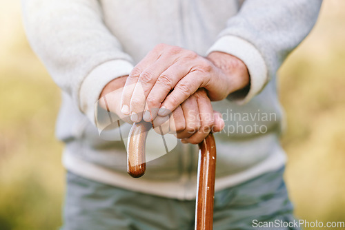 Image of Hands, elderly and retirement, man with walking stick outdoor for walk with fitness and vitality, disability or old age. Old man with cane for support, active lifestyle and wellness in the park.