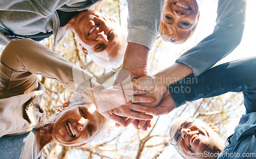 Image of Team work, hands or group of friends in nature for hiking, trekking or fitness training in nature forest. Senior, low angle or happy elderly people in partnership with support, trust or motivation