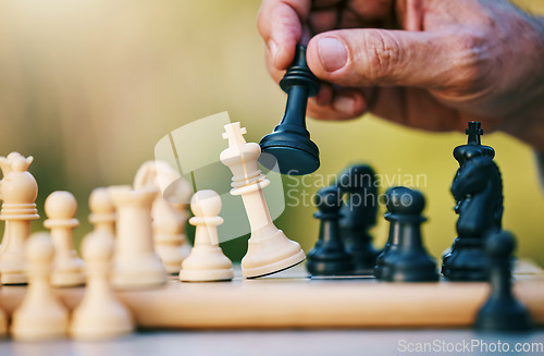 Image of Chess, play or hand with a king on a board game with a winning strategy in a tournament outdoors in nature. Checkmate, mindset or smart man playing in a sports contest or problem solving challenge