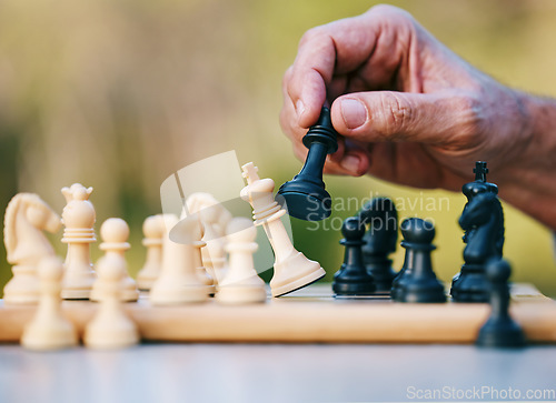 Image of Chess, play or hand with a king on a board game with a winning strategy in a tournament outdoors in nature. Checkmate, mindset or smart man playing in a sports contest or problem solving challenge