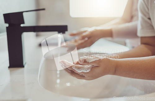 Image of Bathroom, water and child cleaning hands with soap, foam or learning healthy hygiene together. Washing dirt, germs or bacteria on fingers, kid in home in morning for wellness, safety or skin care.