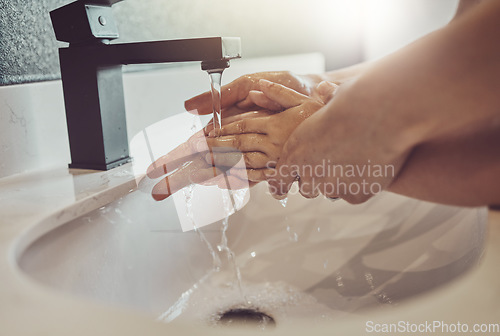 Image of Bathroom, water and parent with child washing hands with soap, foam or learning healthy hygiene together. Washing dirt, germs or bacteria, person and kid in home in morning with help, care or support