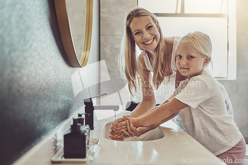 Image of Bathroom, mother and child cleaning hands with water, soap or learning healthy hygiene in portrait together. Washing dirt, germs or bacteria on fingers, mom and girl in home with smile, help and care