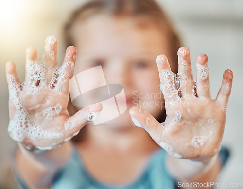 Image of Soap, washing hands and kid with foam for cleaning, hygiene and wellness in bathroom at home. Health, child development and palms of young girl with water for protection for germs, virus and bacteria
