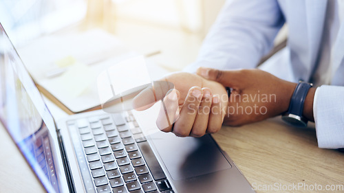 Image of Person, laptop and hands with wrist pain, injury or carpal tunnel syndrome by office desk. Closeup of business employee with sore muscle, ache or joint inflammation from arthritis or strain on table