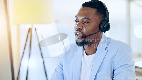 Image of Call center, crm and black man talking for telemarketing, tech support or contact us at help desk in office. Customer service, sales agent and serious consultant in communication, advice and business