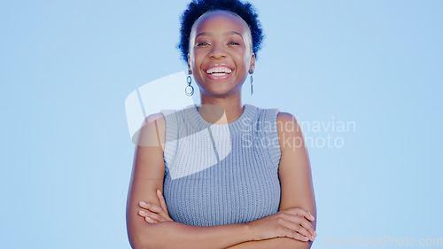 Image of Smile, crossed arms and portrait of black woman in a studio with positive, confident and good attitude. Happy, pride and young African female model with joy and happiness isolated by blue background.