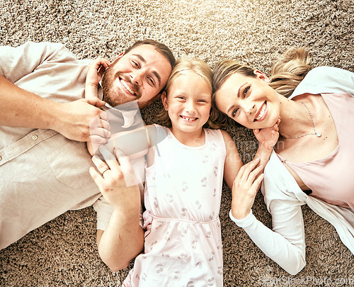 Image of Happy, portrait and kid with parents in the living room bonding and relaxing together at home. Happiness, love and girl child laying with mother and father from Australia on floor in lounge at house.