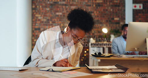 Image of Business woman, writing notes and planning in office for startup goals, administration and schedule or reminder at night. African employee or writer in workspace with notebook, ideas or brainstorming